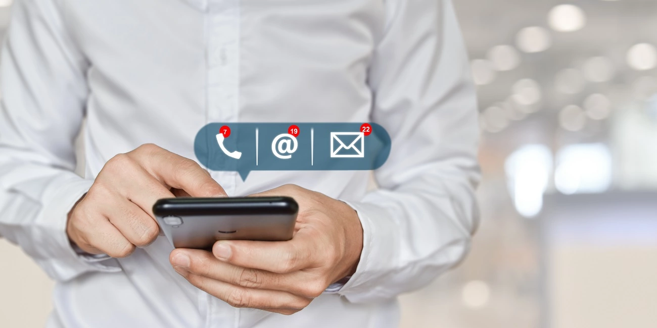 Poslovnjak koji drži mobilni telefon s informacijama o kontaktu